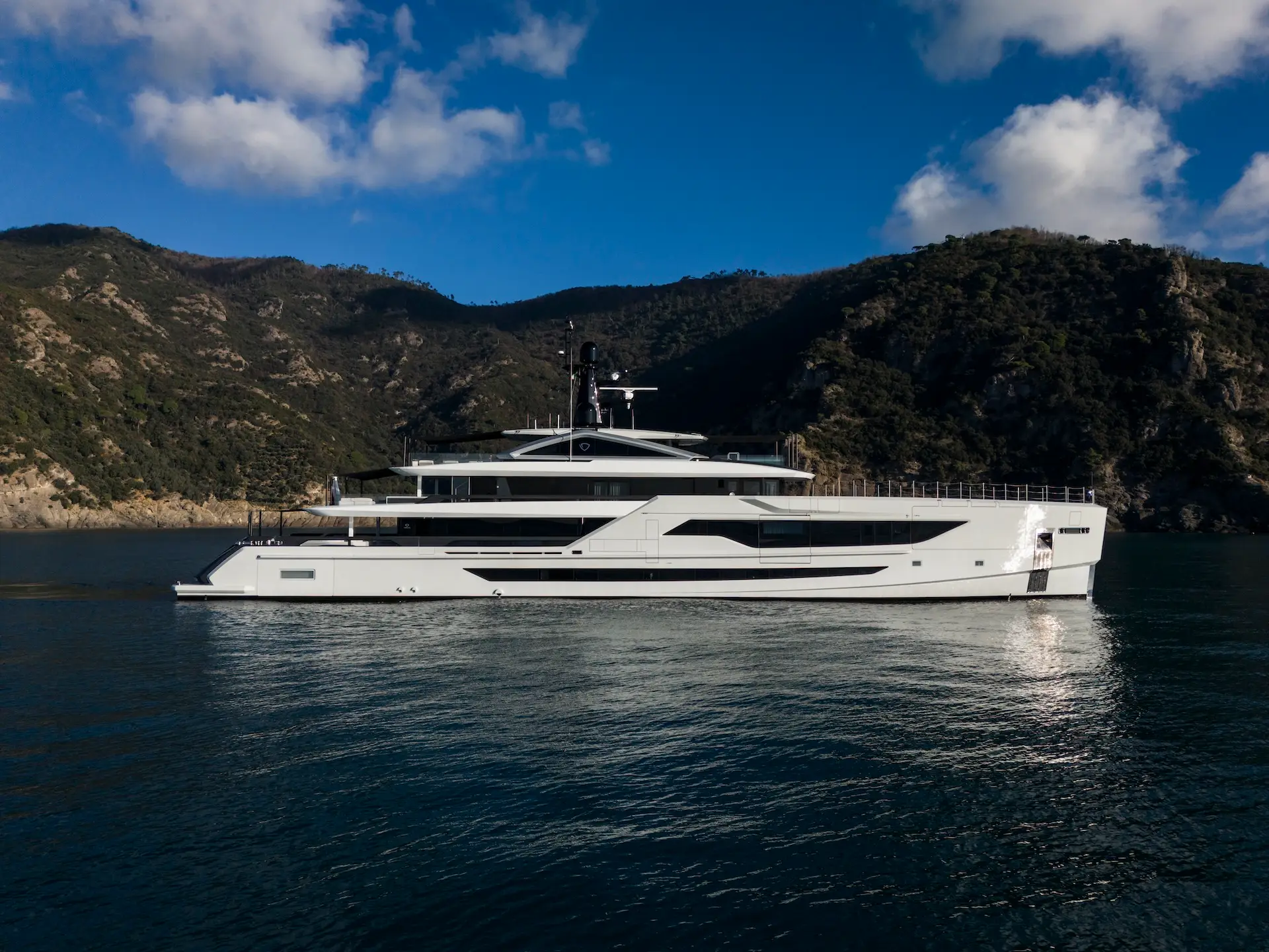 Diamond Binta at anchor with coastline