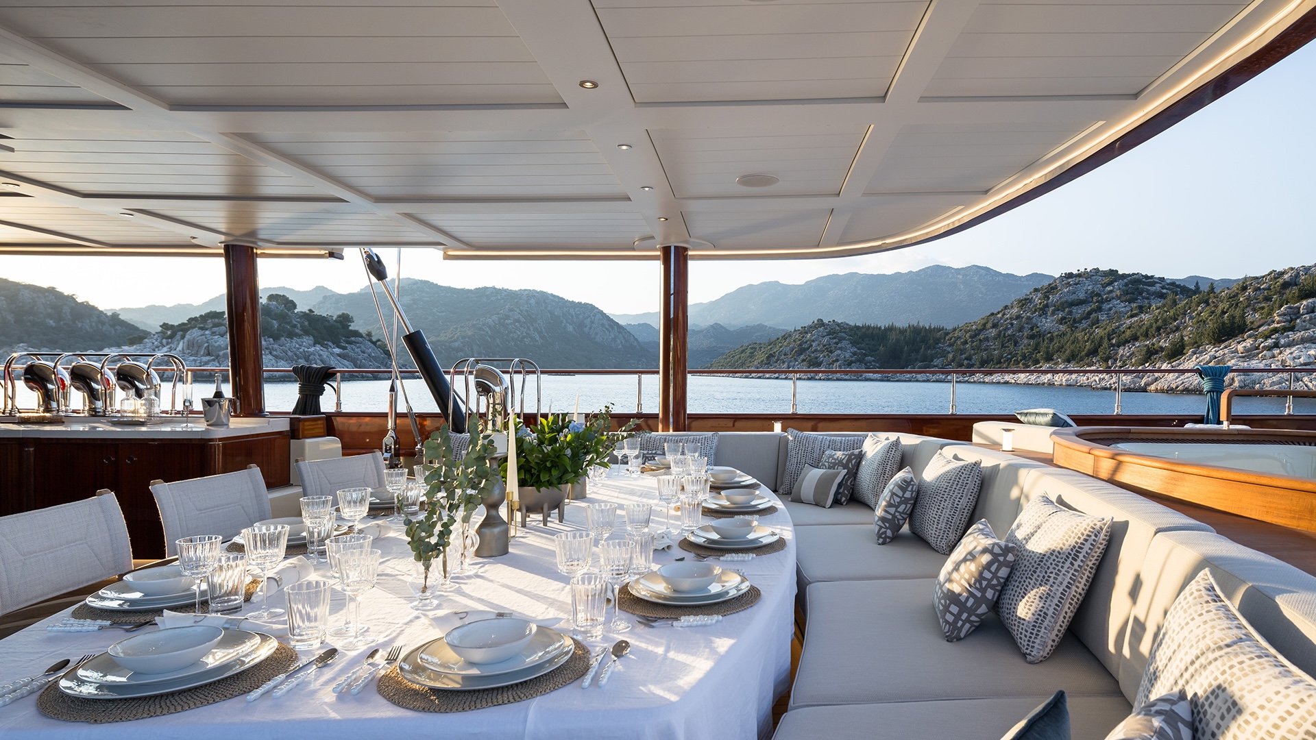 Main deck and aft cockpit on the ARES Simena, with mahogany dining tables and the foundation of the central staircase