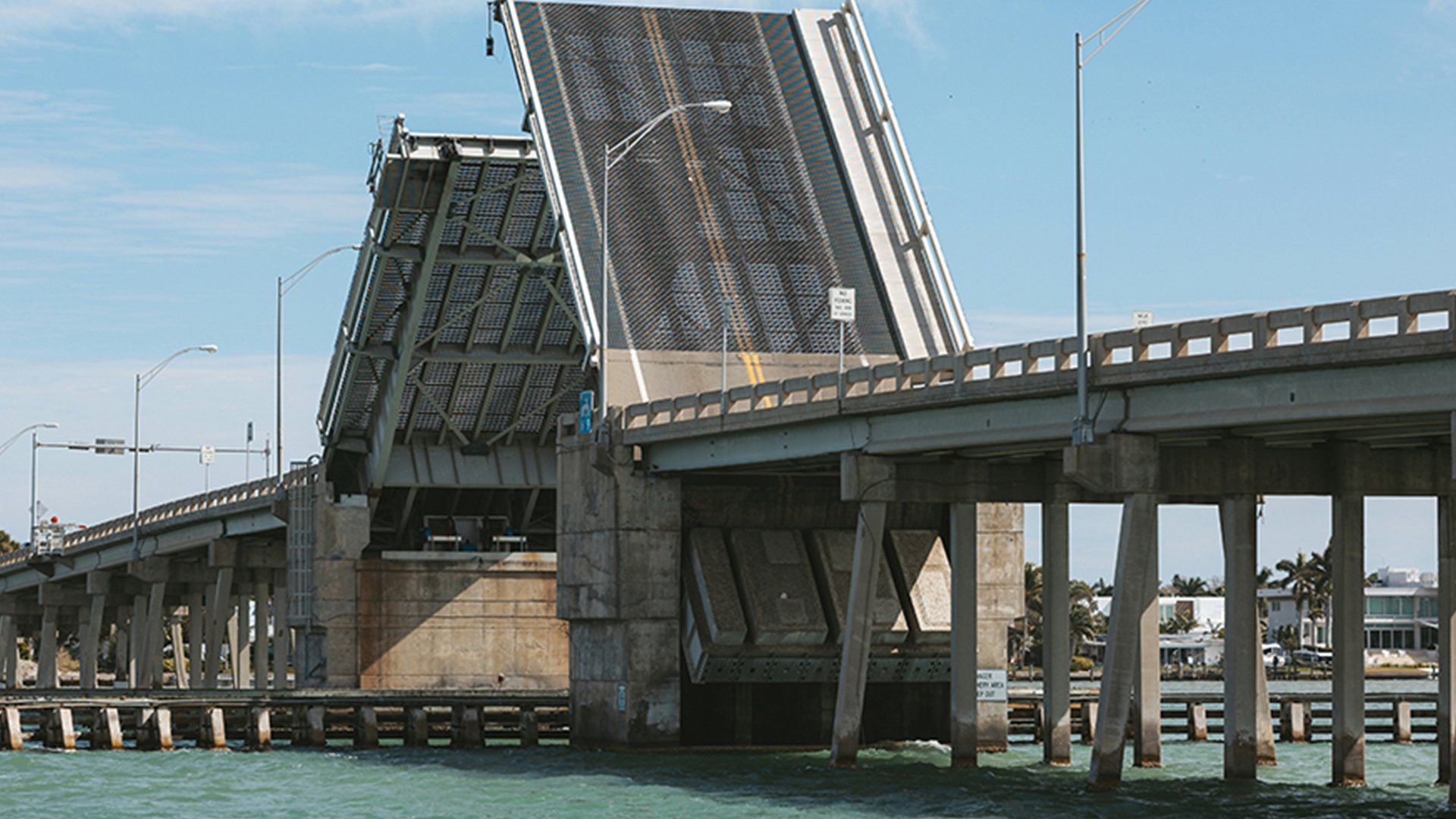Side view of a drawbridge mid-opening, seen from the water