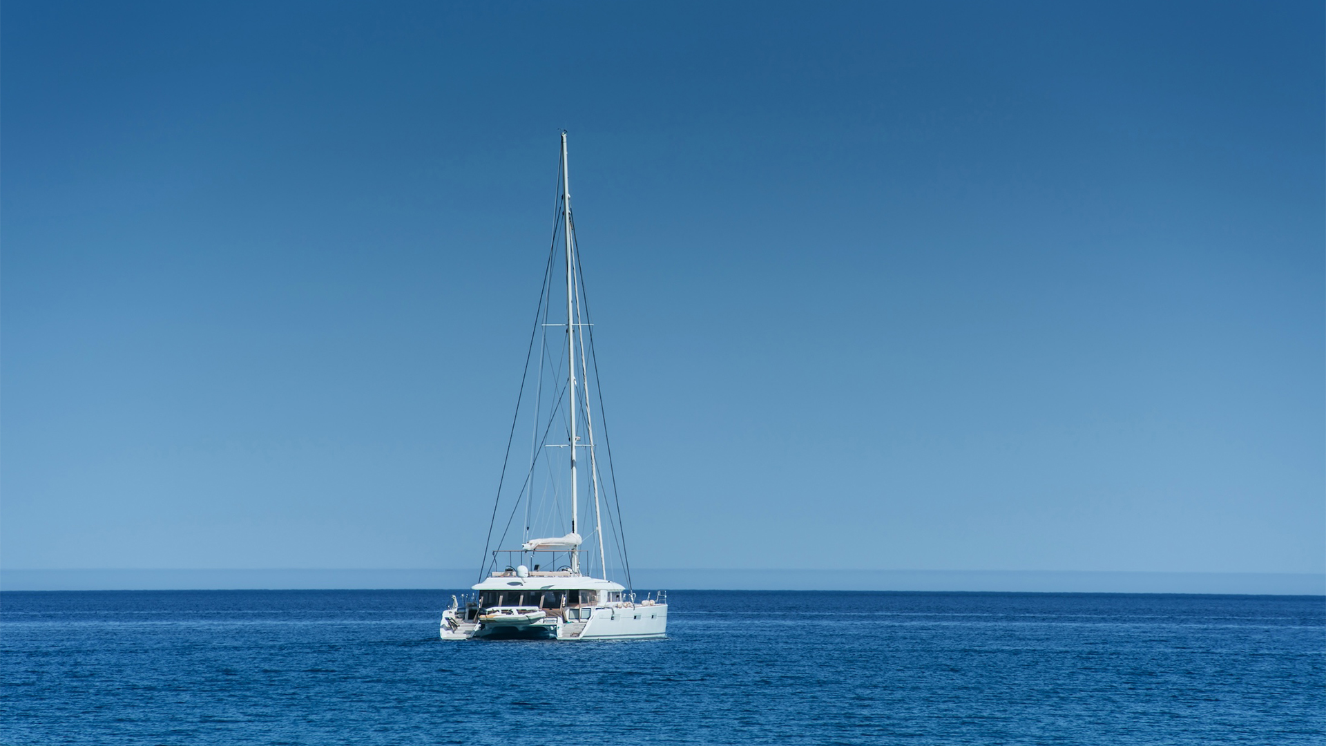 Catamarán blanco fondeado en aguas profundas frente a Eleuthera