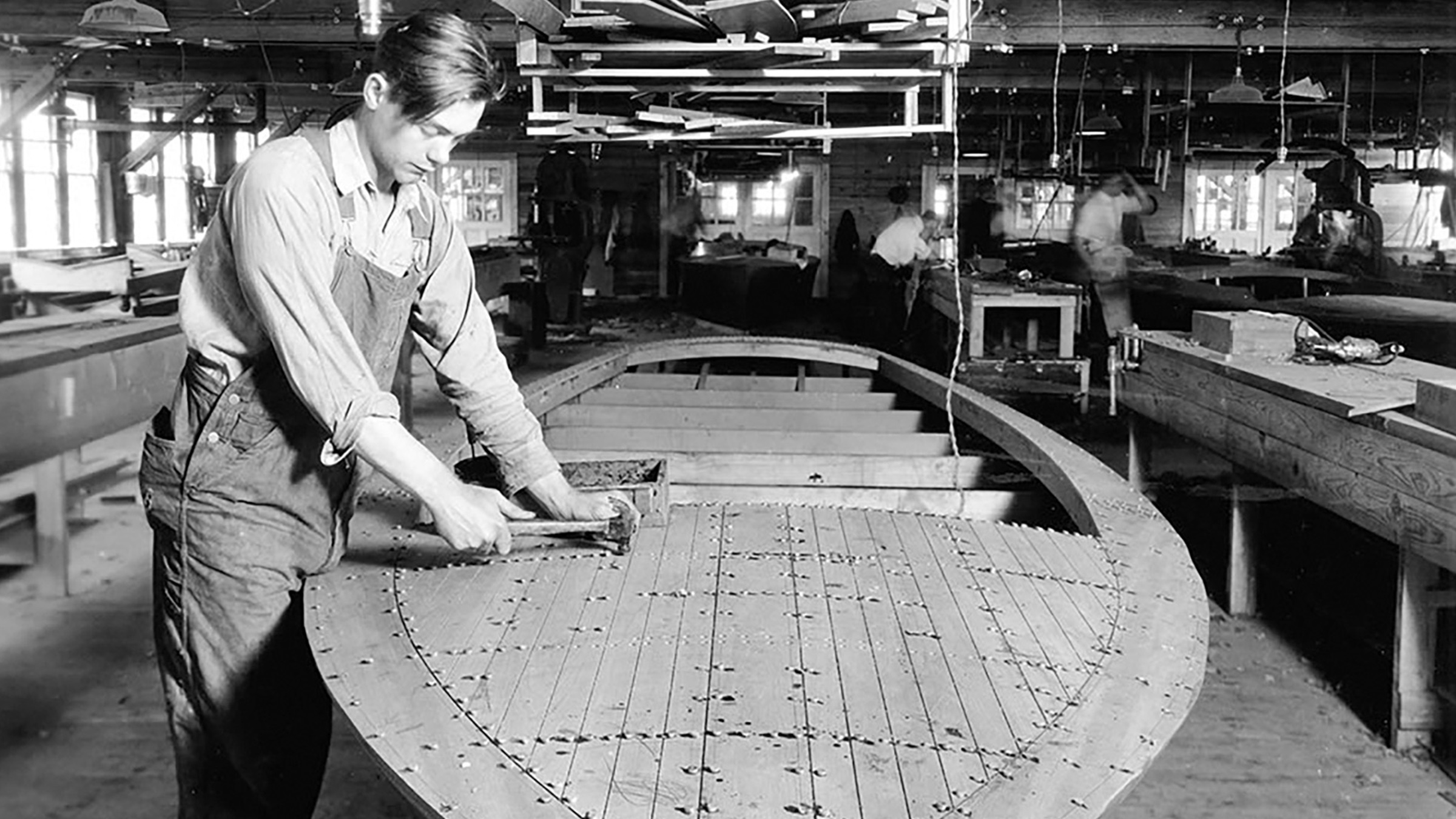 A boatbuilder working on the hull of a Chris-Craft at the shipyard in 1948
