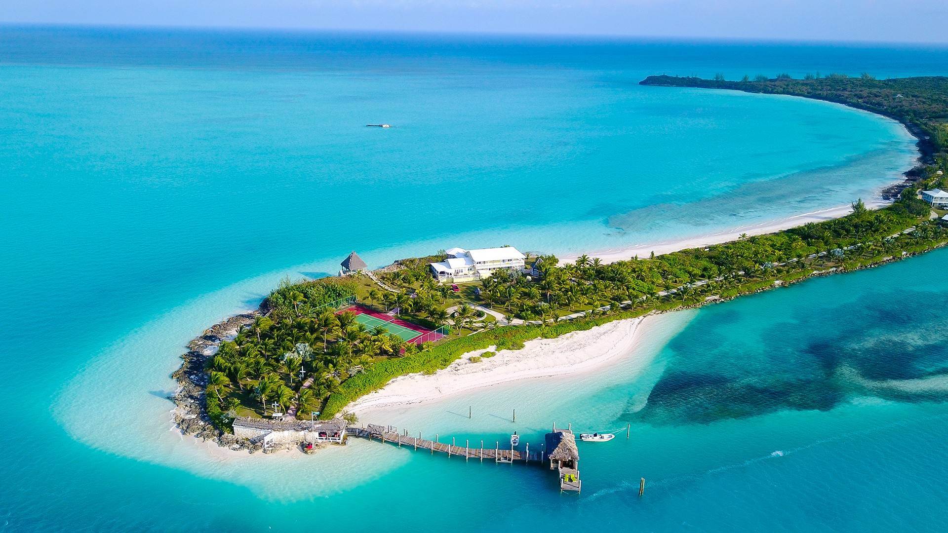 Vista aérea de una propiedad privada en Eleuthera con cancha de tenis, muelle y embarcaciones menores