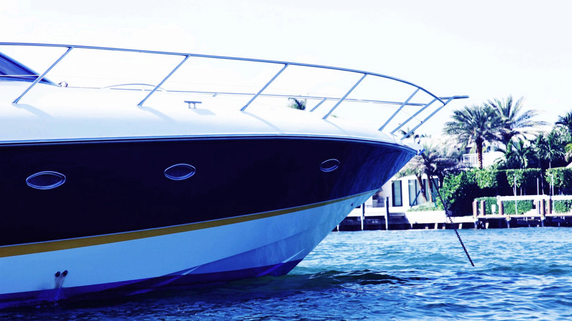 Profile view of a yacht's bow and anchor chain in a channel