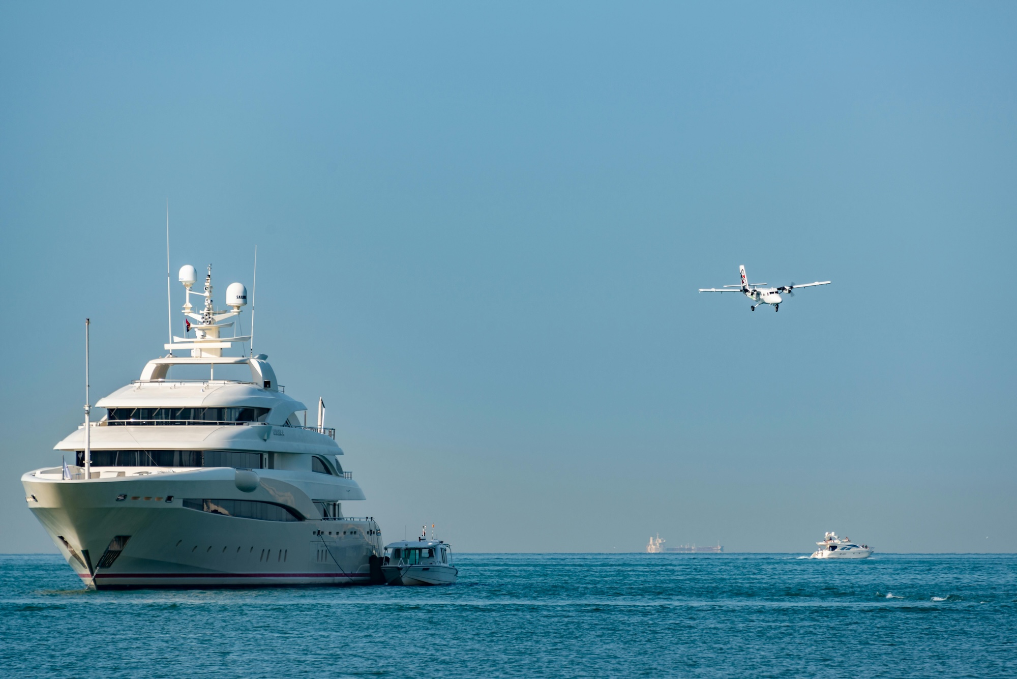 Superyacht at anchor with seaplane alongside