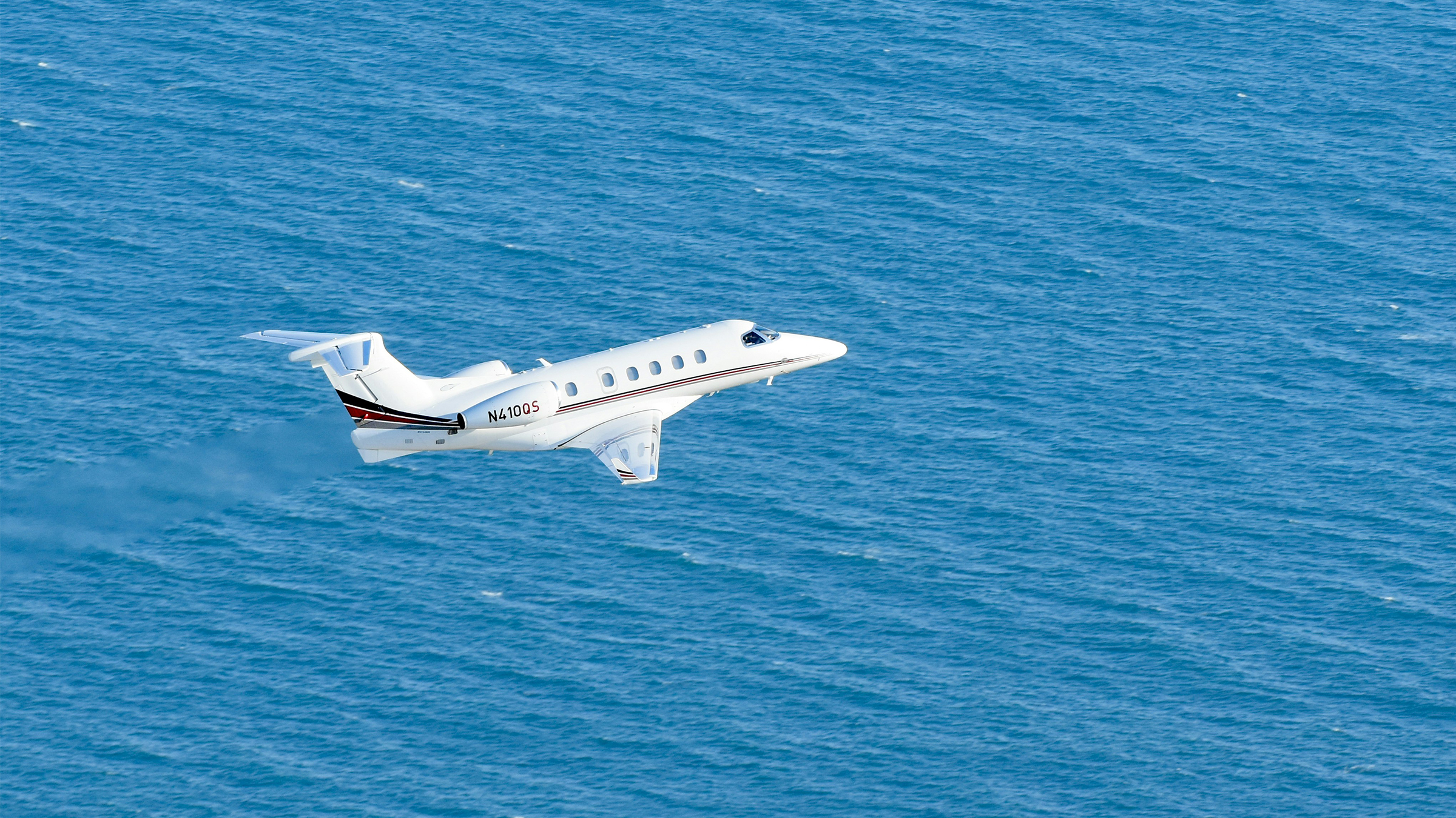 Private aircraft in flight over the open sea