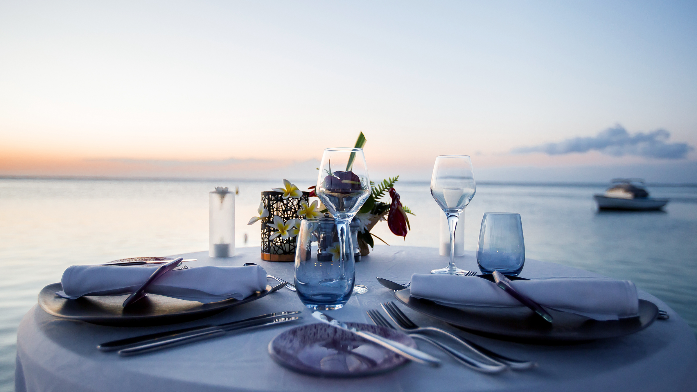 Mesa de cena rom&aacute;ntica en un yate al atardecer